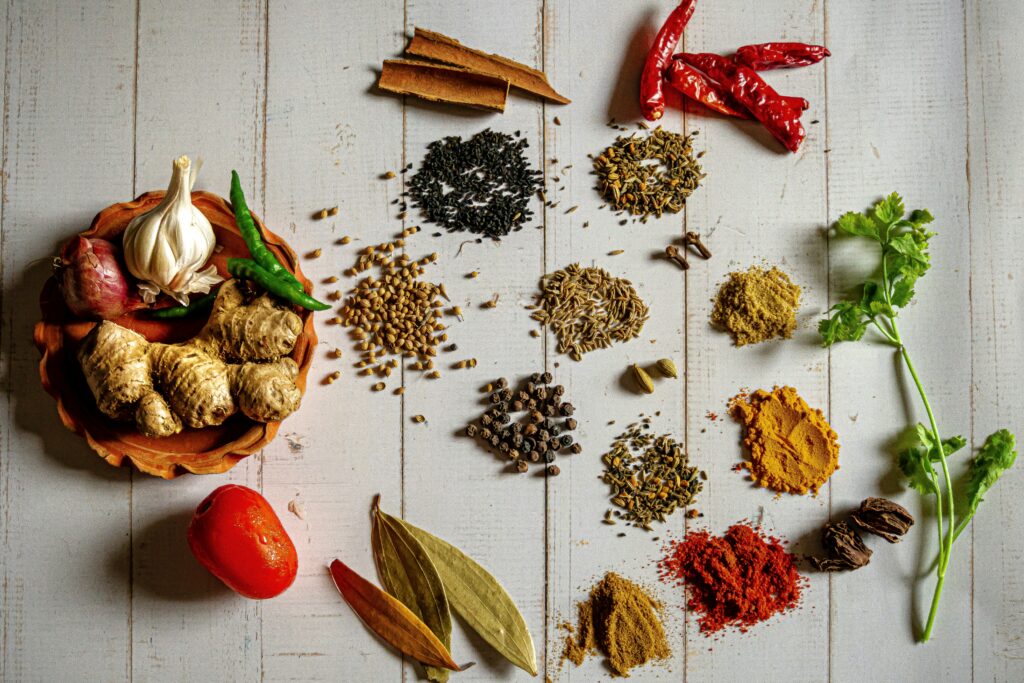 Variety of metabolism-boosting spices including green chilies, red chili flakes, and peppers commonly used in Pakistani and Indian cooking.